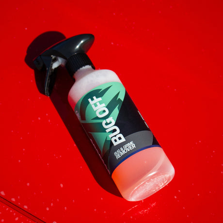 Bottle of Bug Off lay on a red car